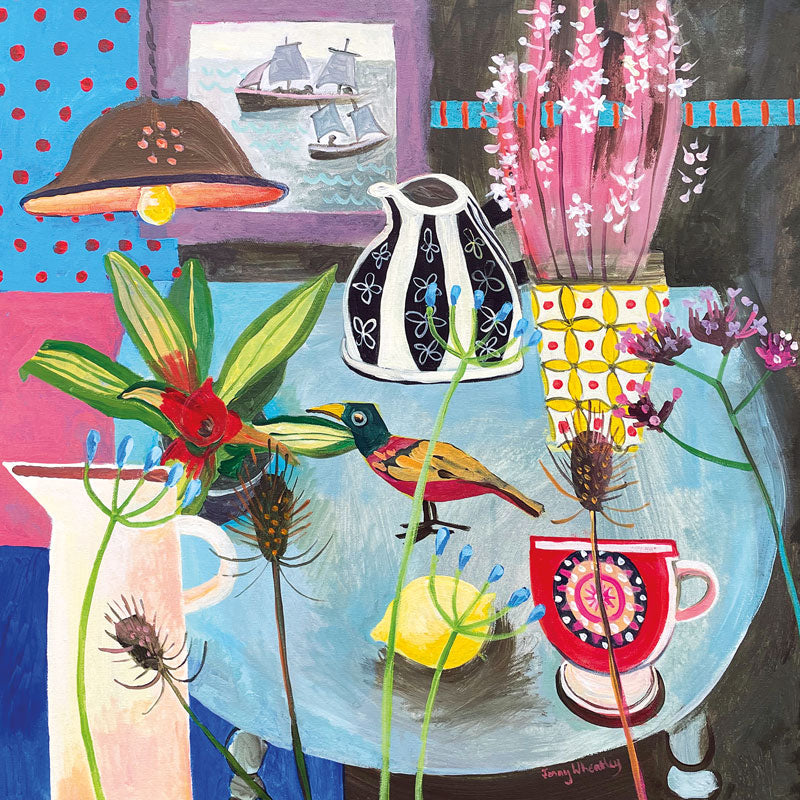 Art greeting card by Jenny Wheatley. Still life with flowers and ornaments on a table with a wooden bird. Sailing boats on the sea out of the window.