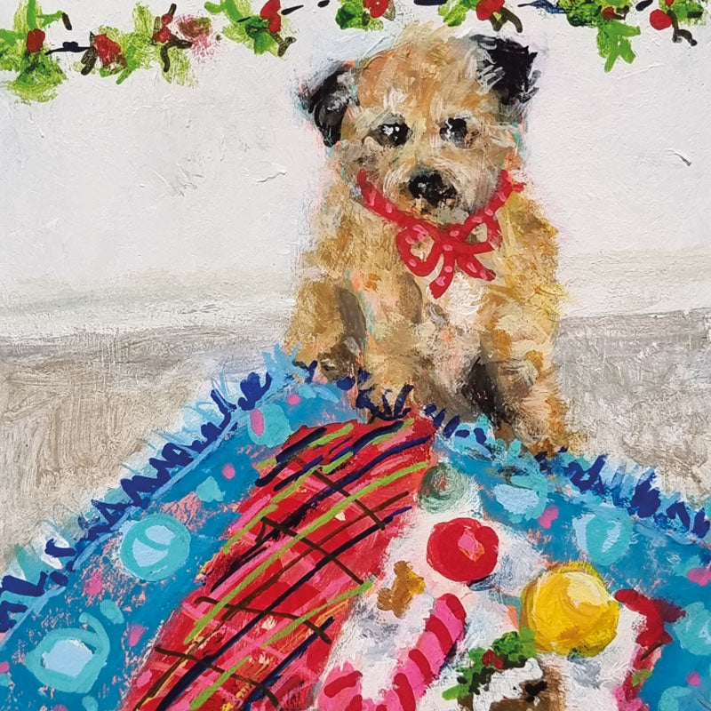 Christmas cards by Jenny Handley. A little brown dog with a red ribbon sitting by Christmas decorations with holly and berries above.
