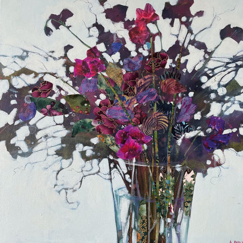 Colourful Sweet Peas in a clear glass vase.