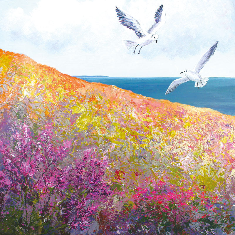 Art greeting card, two seagulls hovering above a cliff with wild flowers and sea in the background.