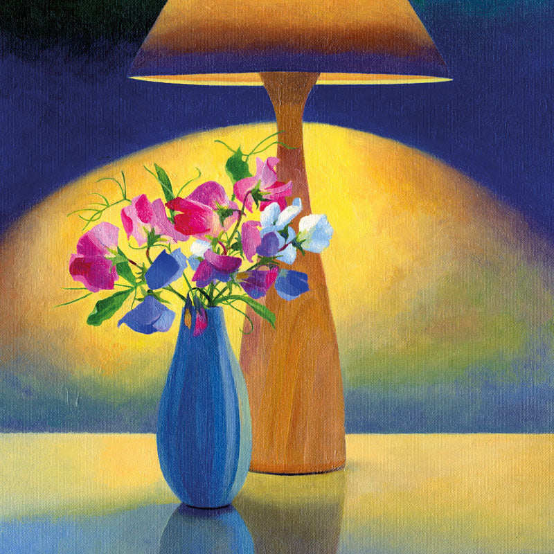 Sweet Peas in a blue vase under a wooden lamp with light on.