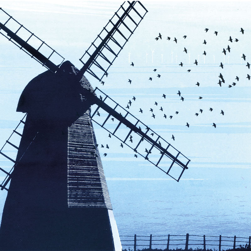 Windmill with the sea in the background and birds flying overhead.