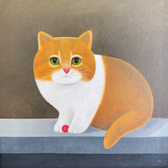 Ginger and white cat with a small red ball between it's paws.